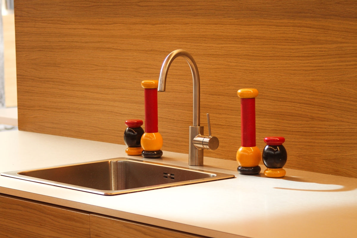 A kitchen sink with a faucet and colorful toy shakers.