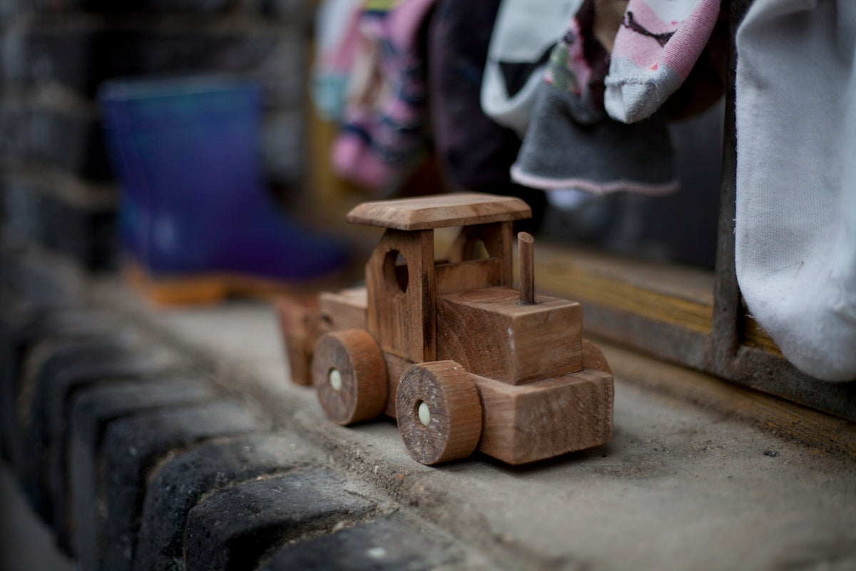 brown wooden vehicle toy on gray concrete surface